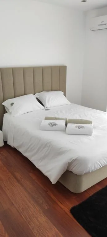 Chambre avec lit double, tête de lit capitonnée et climatisation