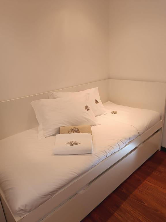 Quarto com cama individual e roupa de casa branca