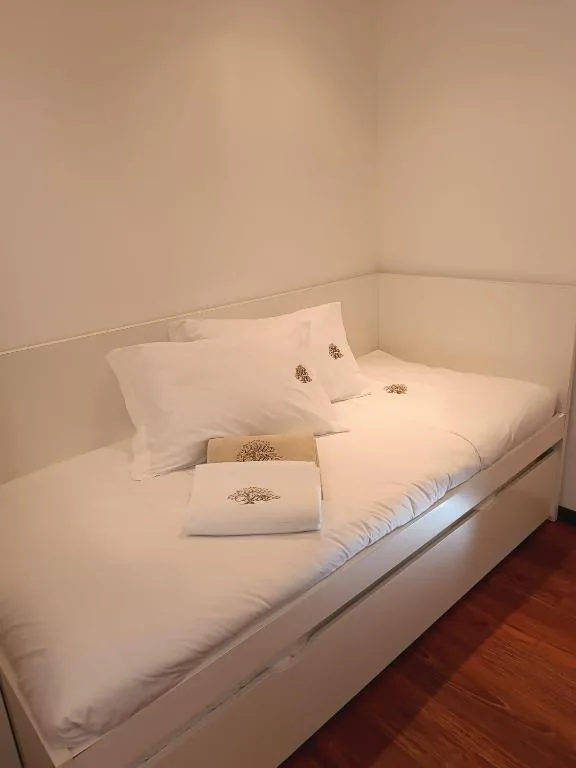 Chambre avec lit simple et linge de maison blanc