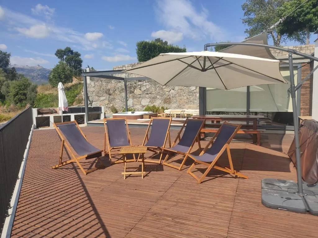 Transats et parasol sur la terrasse, la montagne au fond