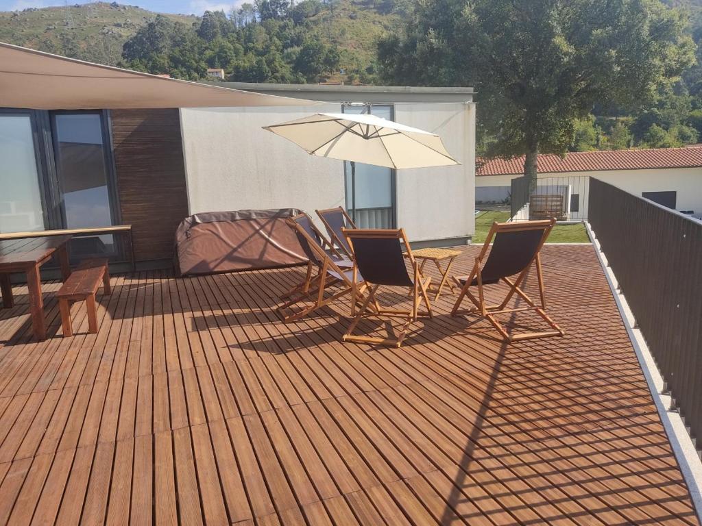 Mesa e cadeiras no deck, junto às portas envidraçadas da sala
